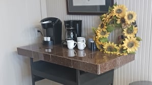 A kitchen counter with a coffee maker, two white cups, and a sunflower decoration. - Recently updated cottage minutes from beach, pet friendly, large yard wifi, ac (Longs)