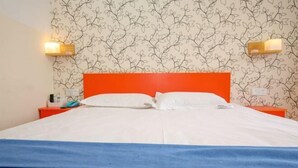 A hotel room with a bed, two bedside tables, and a wall with a leaf pattern. - Pod Inn Hotel (Kunming Municipal Government Chenggong District) (Kunming)