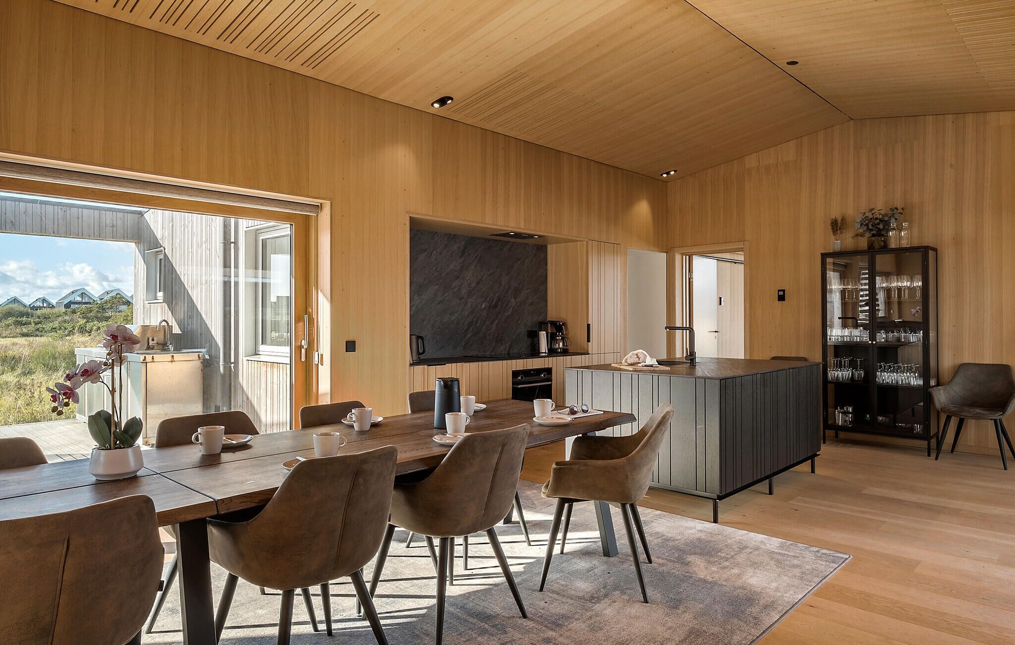 Une cuisine moderne dotée d’un îlot central, de meubles en bois et d’un four encastré.