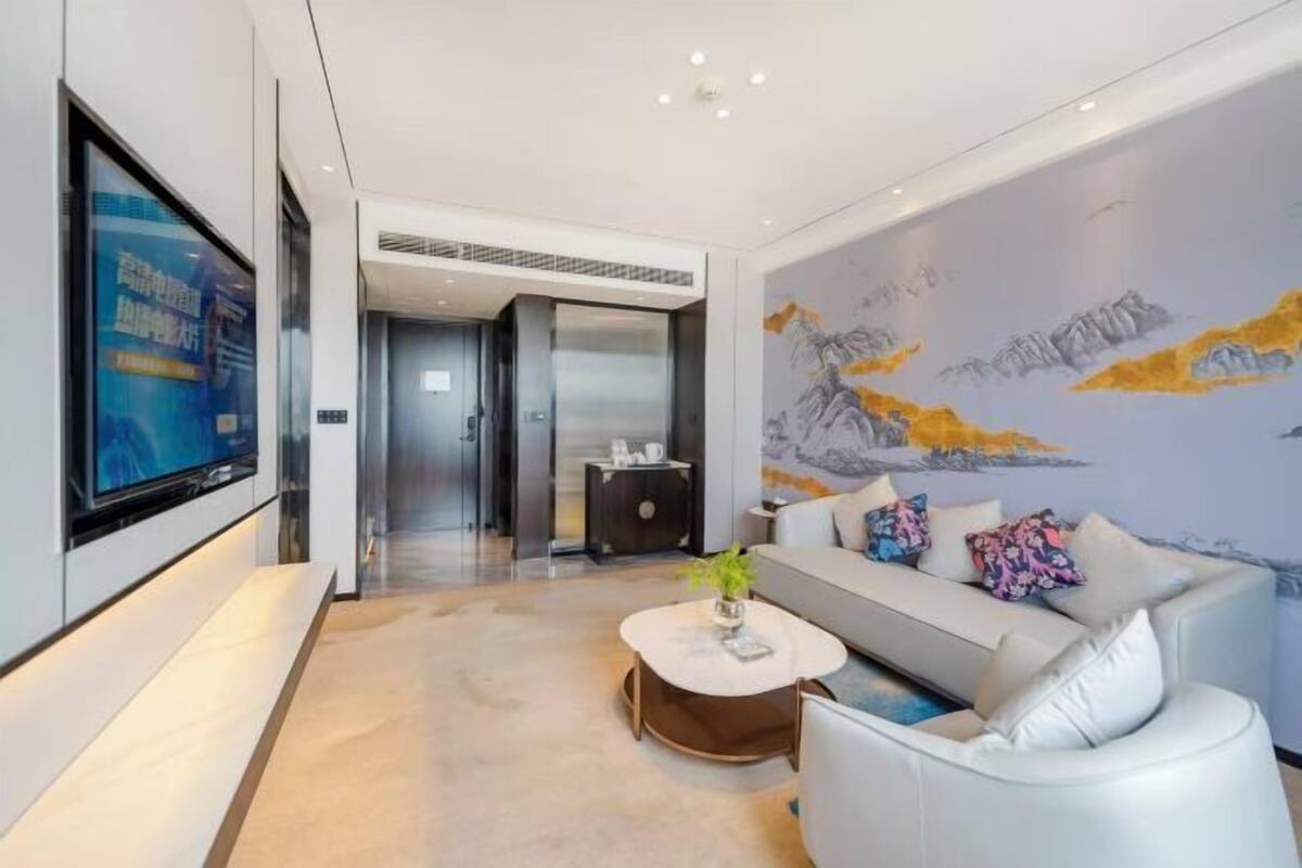 Uma sala de estar moderna com sofá, mesa de centro e obra de arte na parede.