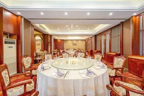 A conference room with a round table, chairs, and a carpeted floor. - Light Grand Hotel (Fengdu County)