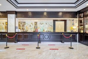 A reception area with a marble floor, a reception desk, and a glass partition. - Light Grand Hotel (Fengdu County)