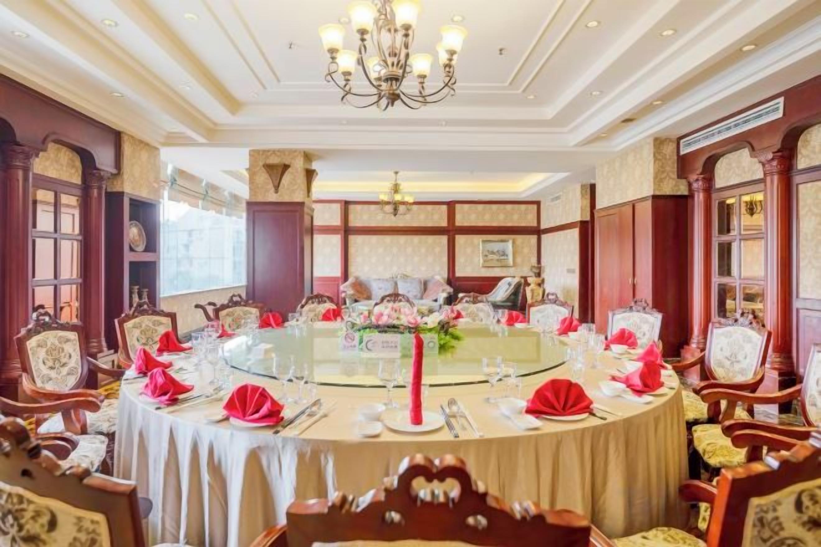 A round table with a glass top surrounded by chairs, set for a formal dining occasion.