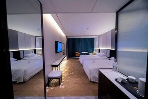 A hotel room with two beds, a TV, a desk, and a small table. - Light Grand Hotel (Fengdu County)