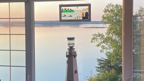 Ein Zimmer mit Blick auf einen ruhigen See, durch ein Fenster mit einem dekorativen Buntglasfenster darüber.