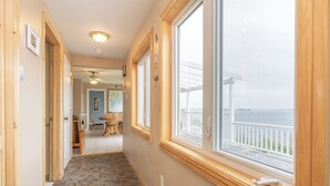 Ein Flur mit Meerblick, ein Essbereich mit Stühlen und ein Deckenventilator.
