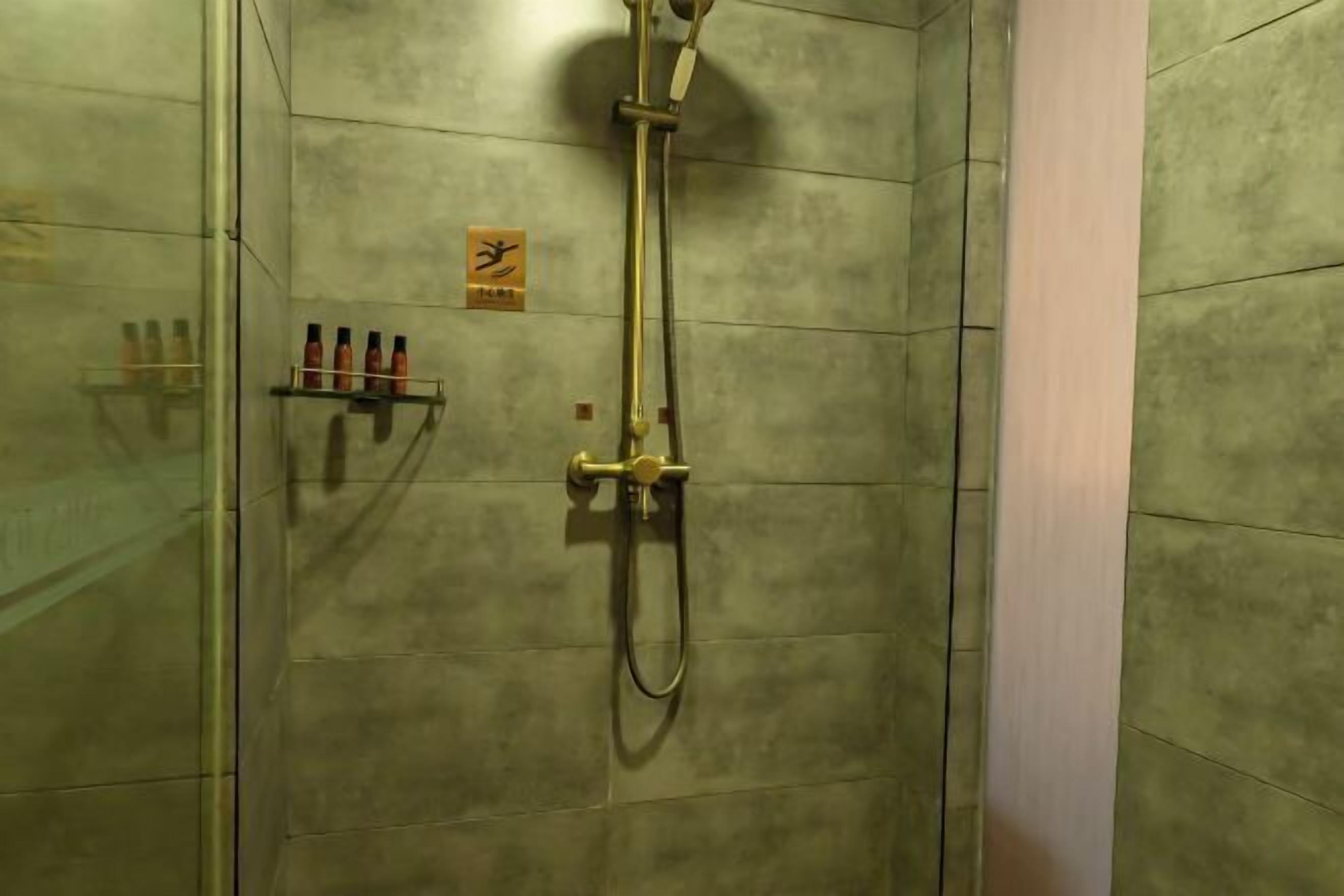 A shower with a handheld showerhead and a wall-mounted faucet.