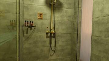 A shower with a handheld showerhead and a wall-mounted faucet.
