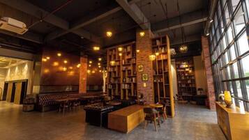 Un grand espace intérieur comprenant un bar, des sièges et des étagères à livres.