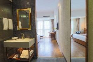 A hotel bathroom with a sink, mirror, and towel rack. - Zhehui Hotel (Zhongshan)
