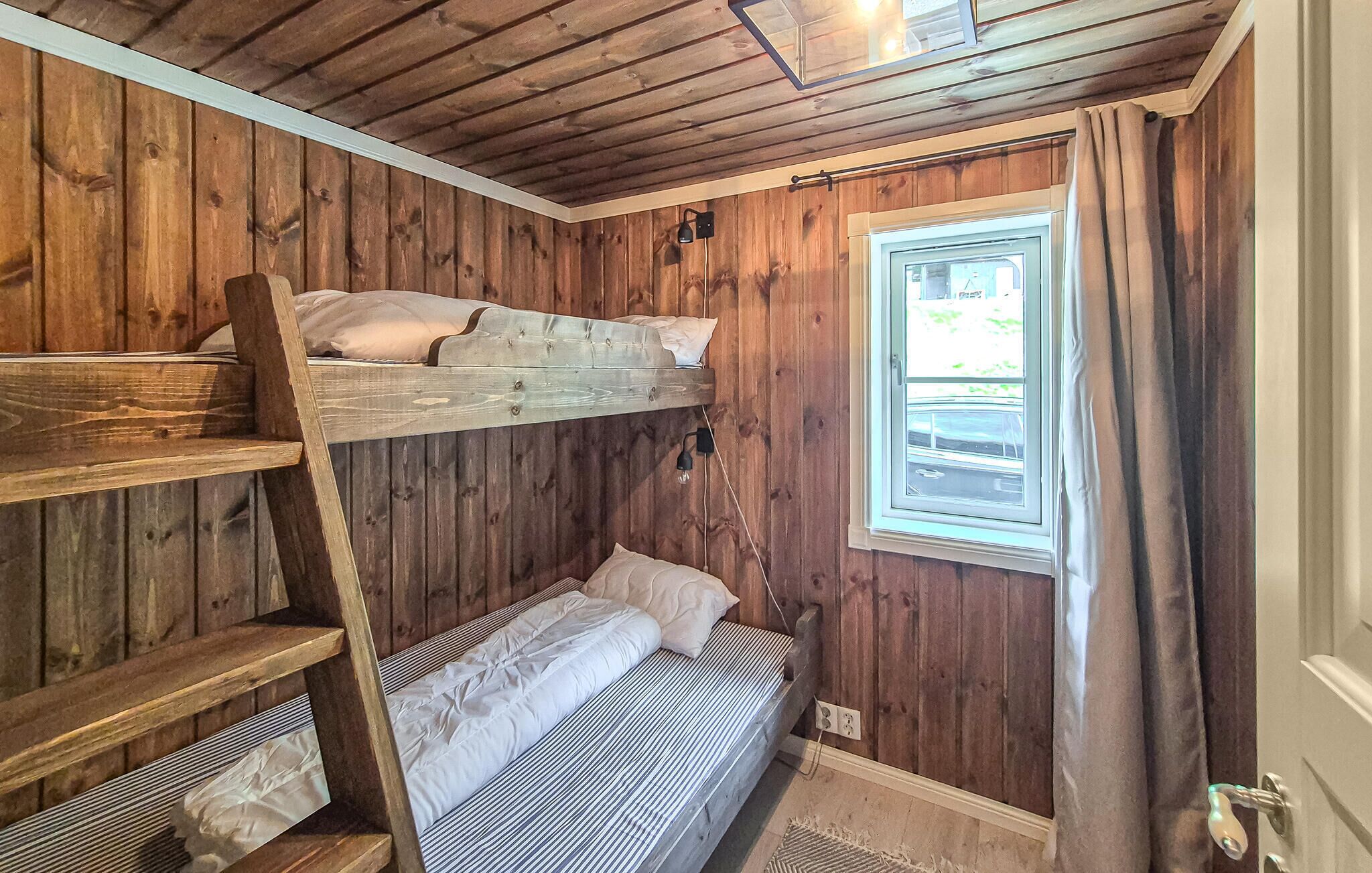 A bunk bed room with wooden walls and a window.