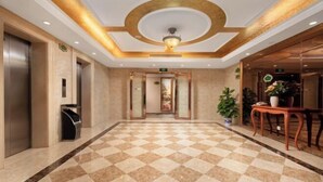 A hotel lobby with a checkered floor, elevators, a reception desk, and a decorative ceiling. - Vienna Classic Hotel (Shenzhen MixC Mall) (Shenzhen)