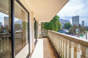 A balcony with a view of a cityscape, a railing, and a potted plant. - Bakong Hotel (Siem Reap)
