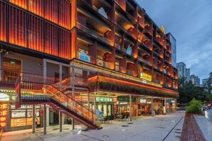 Hotel de vários andares com design moderno, com varandas e restaurante no térreo.