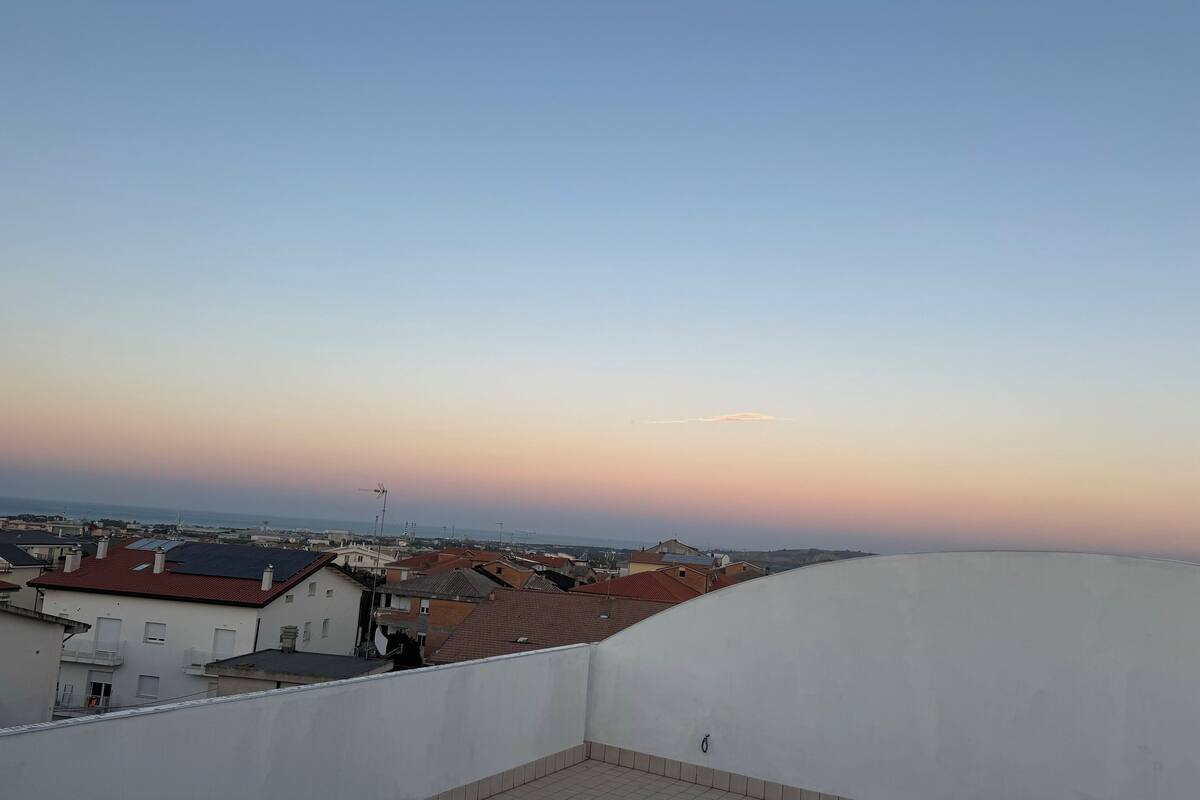 Ein Wohngebiet mit mehreren Gebäuden, blauem Himmel und weiter Meerblick.
