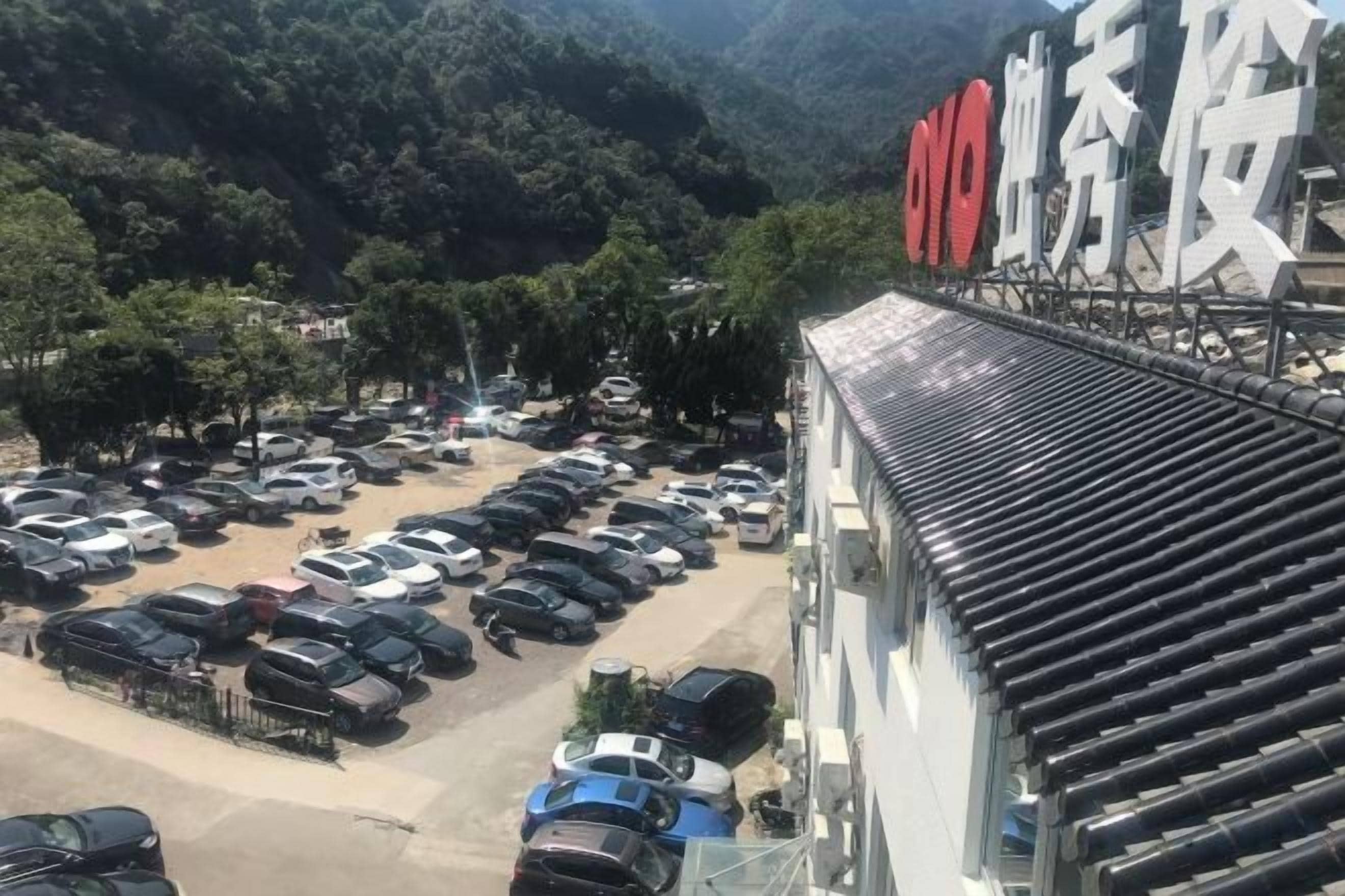 A parking lot with multiple cars and a building with a sign.