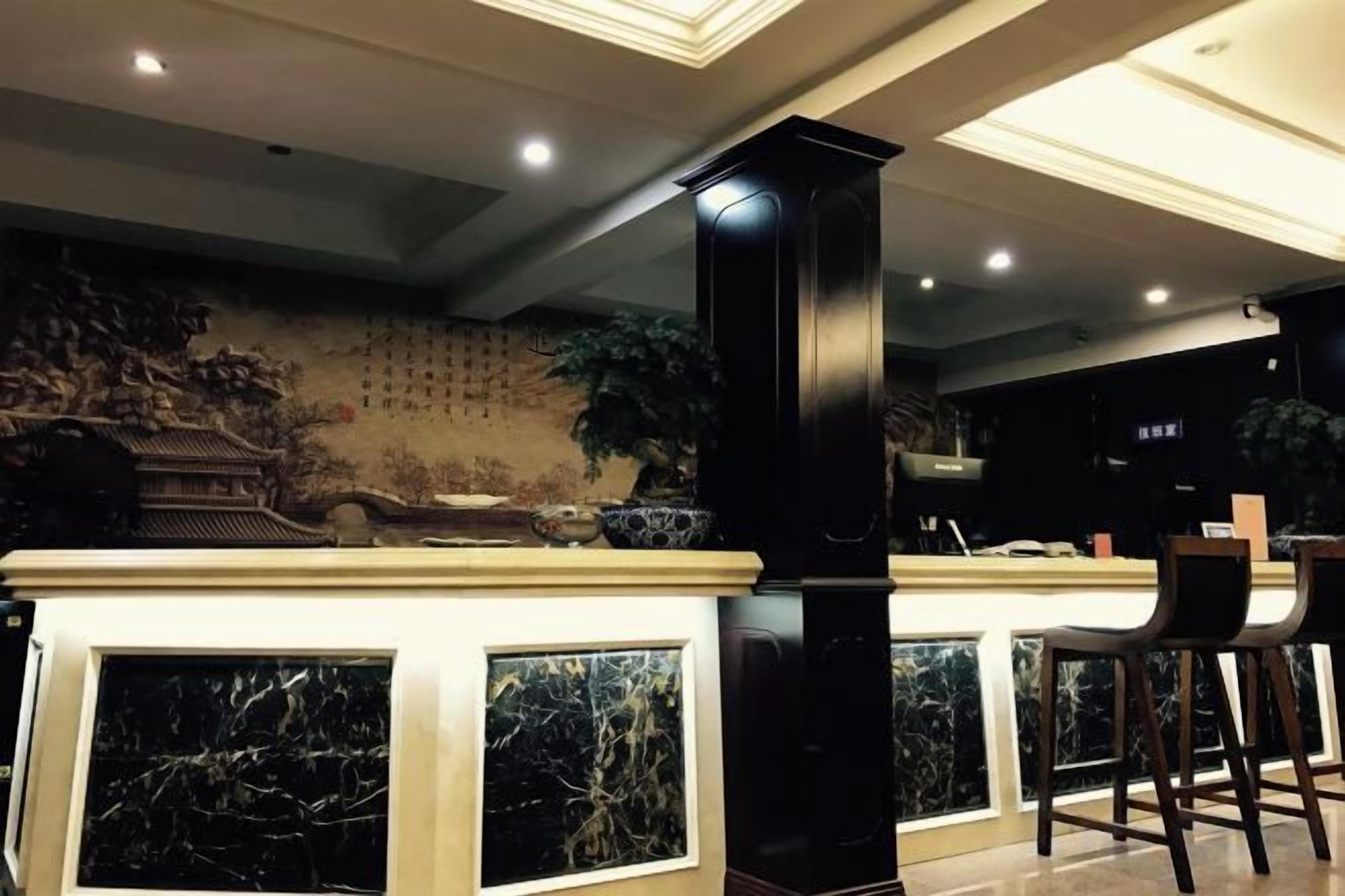 A bar area with a traditional mural, a black pillar, and bar stools.
