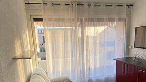 Ein modernes Wohnzimmer mit einer Couch, einem weißen Tisch und einem roten Schrank.