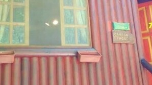 Ein Gebäude mit einem Fenster und einem Schild mit der Aufschrift 'Caring for the Planet'.