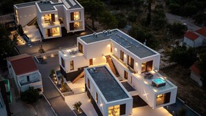 Un immeuble résidentiel moderne à plusieurs étages, doté d’une piscine sur le toit et de panneaux solaires.