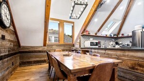 Eine rustikale Küche mit Holzwänden, einem Holztisch und Blick durch ein Oberlicht.