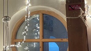 A room with a round window, a framed picture, and string lights. - Cosy seaside cottage one minute walk from the beach. Dog friendly! (Cromer)