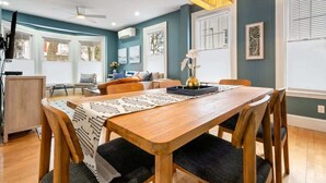 A dining area with a wooden table and chairs, a ceiling fan, and a decorative light fixture. - Workspace | Soaking Tub | W/D | 5 Min Downtown (Portland)