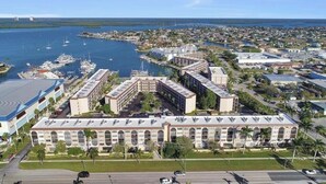 Ein großes Hotel mit Innenhof, mehreren Flügeln und einem Hafen mit Booten.