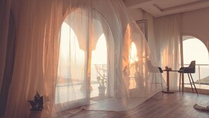 A room with large arched windows, a dining table with chairs, and a view of the sea. - Magnifique Villa Avec Piscine et vue sur mer & Montagnes (Béja Governorate)