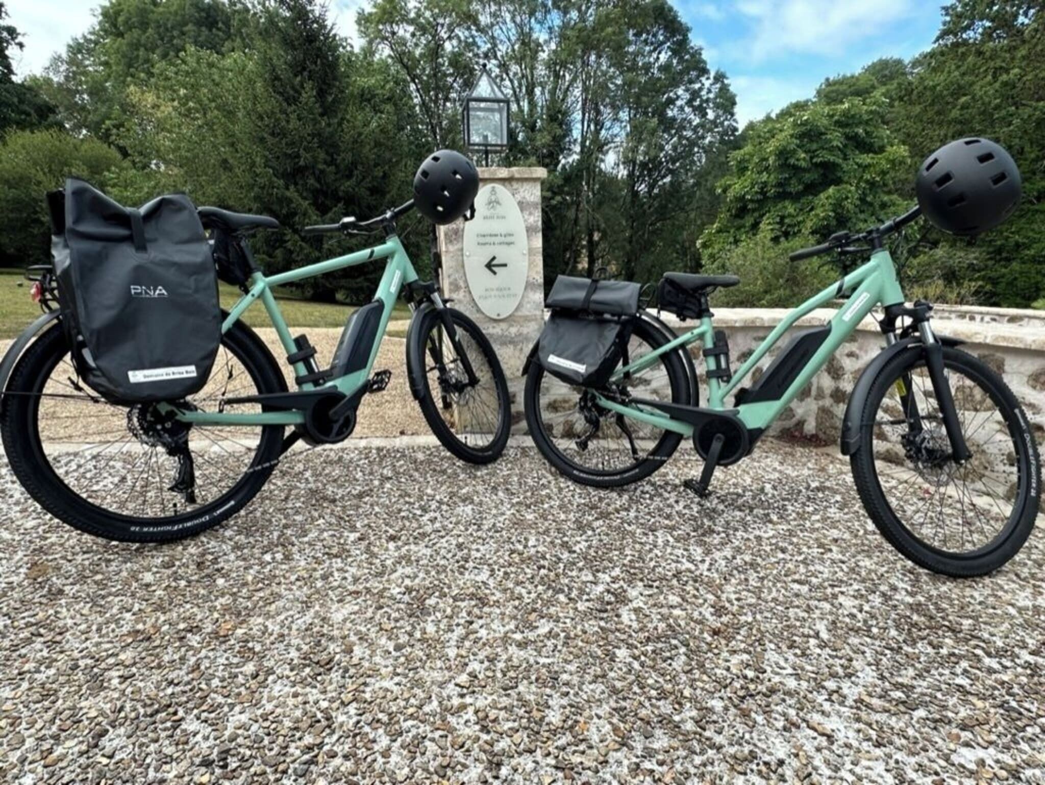 Zwei E-Bikes auf einem Kiesgrund, im Hintergrund ein Steinmonument.