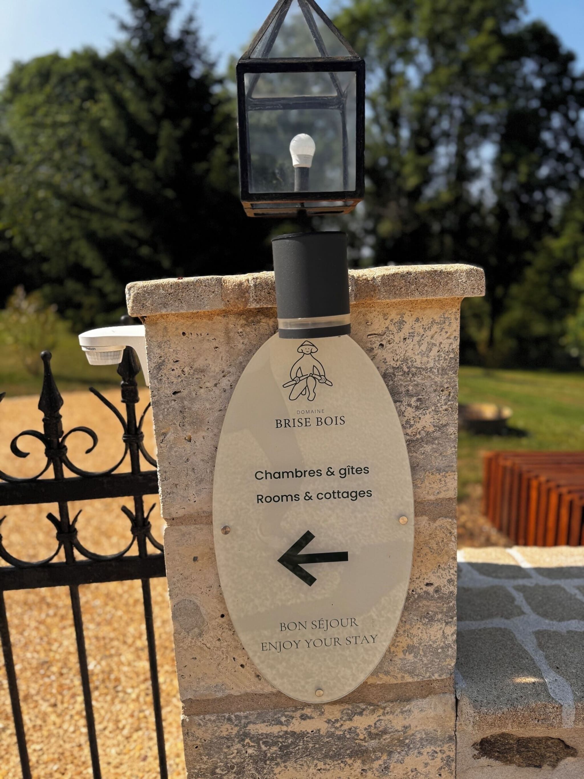 Un panneau de signalisation indiquant « Chambres et gîtes » avec une flèche pointant vers la gauche, indiquant la direction à suivre pour trouver les chambres et les maisons de vacances.