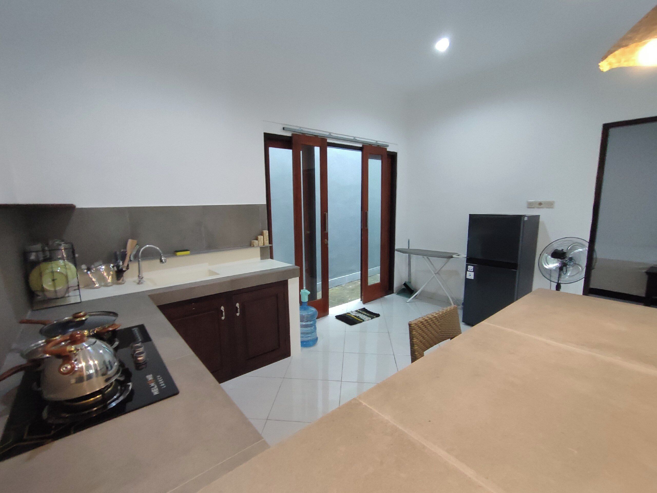 A compact kitchen with a sink, stove, and a refrigerator.