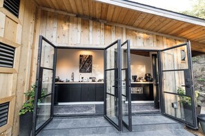 A modern kitchen with a black countertop, a sink, and a coffee machine. - The Lodge: A Spacious Retreat for Groups - Events, Nature, & Luxury Combined! (Julian)