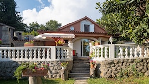 A house with a stone facade, a balcony with a white balustrade, and a set of stone steps leading to the entrance. - Stunning home in Rijeka with WiFi (Rijeka)
