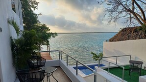 A balcony with a view of the sea, a small pool, and outdoor seating. - ZENSUS LAGUNA (Bacalar)