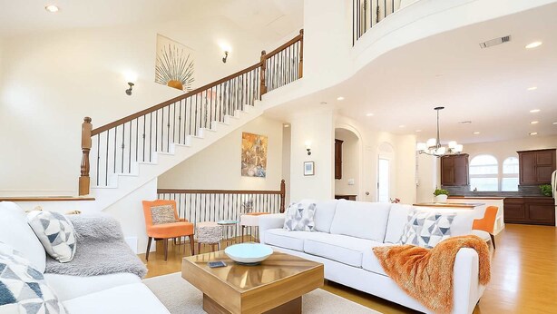 A spacious living room with a staircase, a dining area, and a kitchen. - Galleria Ashford Retreat | Jacuzzi | Sleeps 9 (Houston)