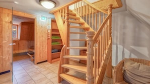 Eine Holztreppe mit Handlauf, die zu einer zweiten Etage führt.