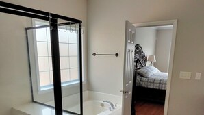 A modern bathroom with a glass-enclosed shower, a freestanding bathtub, and a walk-in shower.