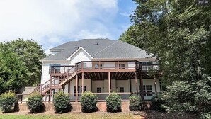 A two-story house with a covered porch and a staircase leading to the upper level.