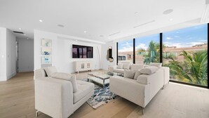 A modern living room with a large window, a flat-screen TV, and a minimalist design. - 1062 Managed by Brampton Park (Delray Beach)