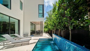 A modern house with a swimming pool, lounge chairs, and a patio area. - 1062 Managed by Brampton Park (Delray Beach)