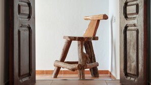 Ein schlichter Holzstuhl in einer Türöffnung.