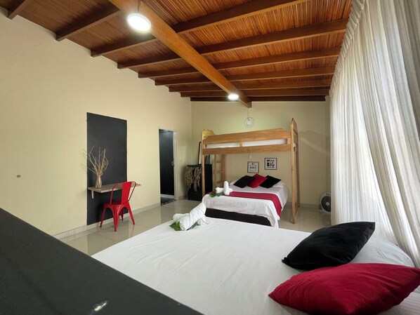 A bedroom with a bunk bed, a desk, and a chair.
