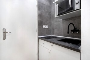 A kitchen with a microwave, sink, and cabinets.
