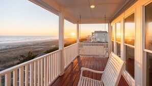 A wooden deck with white railings overlooking a beach at sunset. - 🌊 Luxe Oceanfront Escape 4BR + Private Pool & Stunning Views (Holden Beach)