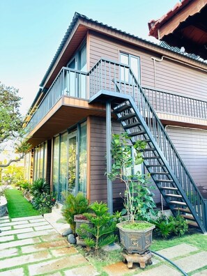 Een huis met twee verdiepingen, een balkon en een trap naar de bovenverdieping.