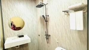Ein Badezimmer mit Toilette, Waschbecken, Spiegel und Dusche.