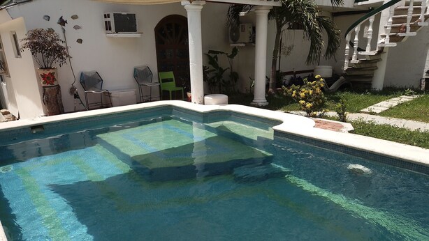 A rectangular swimming pool with clear blue water, surrounded by a white wall with decorative tiles. - Casa, "Joy of the Sea" (Puerto Morelos)