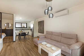 A modern living room with a sofa, dining table, and pendant lights. - Vacation Home 'Rincón De La Fontana' with Mountain View, Wi-Fi and Air Conditioning (Las Palmas)