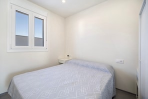 A bedroom with a bed, a window, a bedside table, and a power outlet. - Holiday Home 'Villa Kalma' with Private Pool, Private Terrace and Wi-Fi (Chiclana de la Frontera)